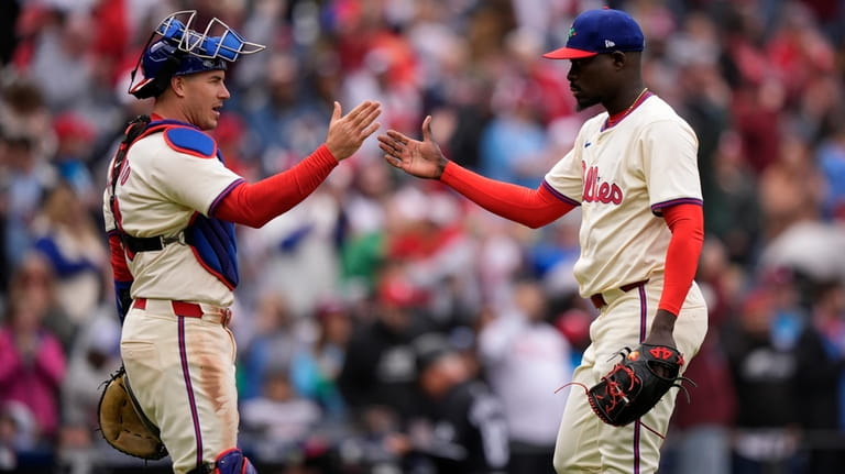 Philadelphia Phillies' J.T. Realmuto, left, and Yunior Marte celebrate after...