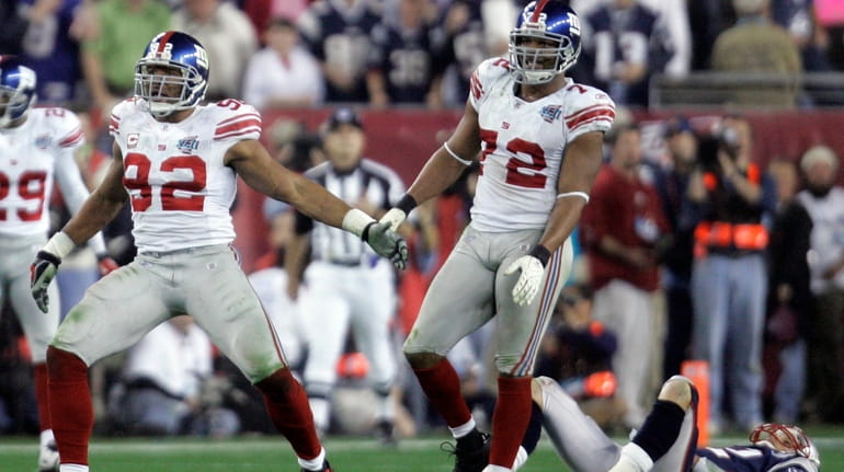Giants' Michael Strahan, left, and Osi Umenyiora celebrate after Strahan...
