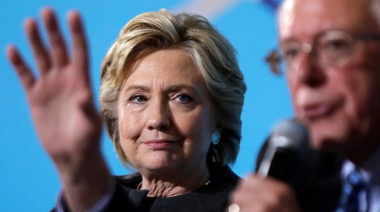 Democratic presidential candidate Hillary Clinton listens as Sen. Bernie Sanders,...