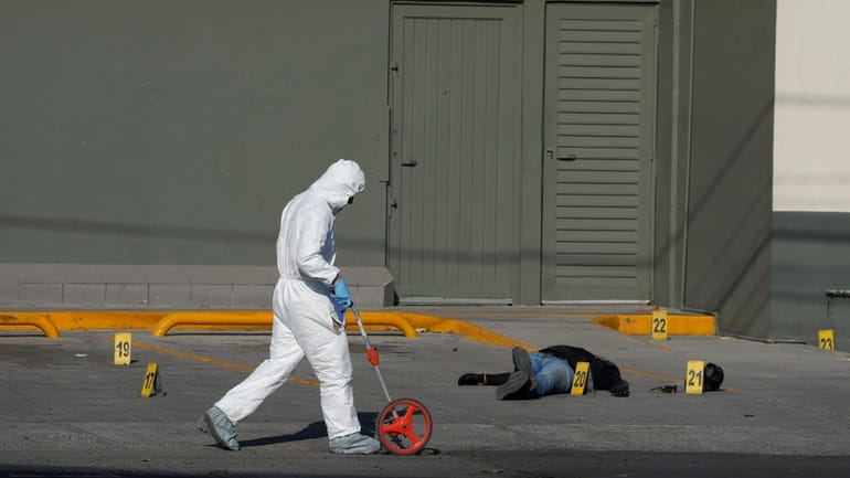 A police investigator collects evidence at a crime scene where...
