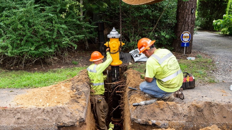 Contractors for the Suffolk County Water Authority install fire hydrant...