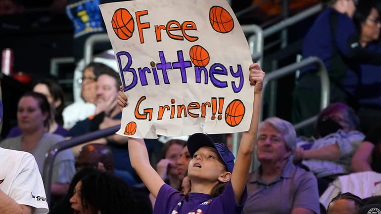 A young Phoenix Mercury fan holds up a sign "Free...