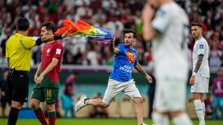 A pitch invader runs across the field with a rainbow...