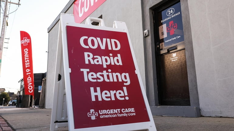 A sign advertising COVID-19 rapid testing outside of AFC Urgent...