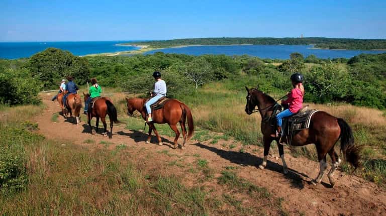 Horseback riders from nearby Deep Hollow Ranch make their way...