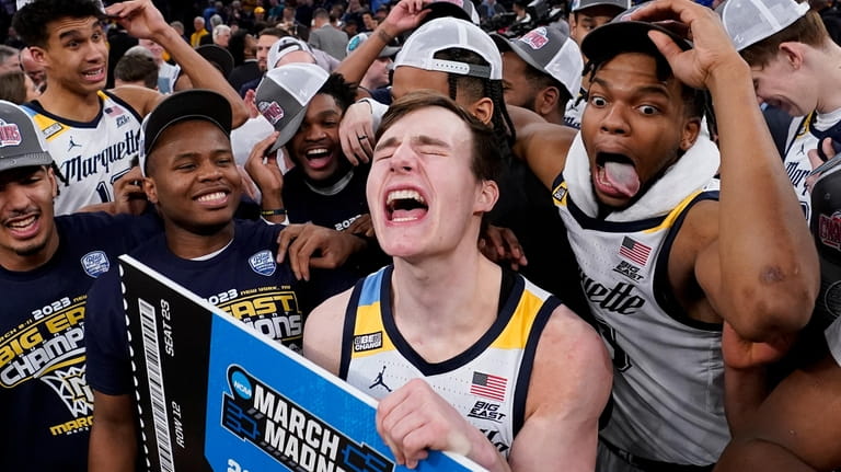 Marquette's Tyler Kolek, center, the tournament's most outstanding player, celebrates...