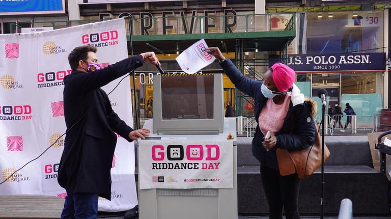Jonathan Bennett, left, assists people in Times Square bid one...