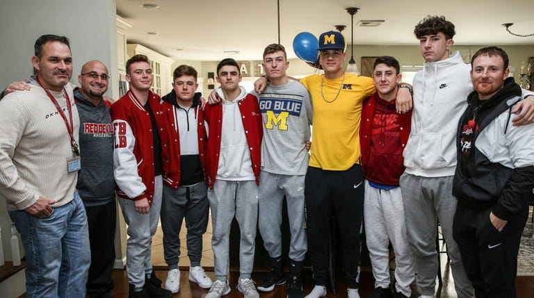 Plainedge's Dan Villari, fourth from right in yellow, poses with...