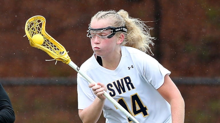 Shoreham-Wading River midfield Carlie Cutinella looks to set up a...