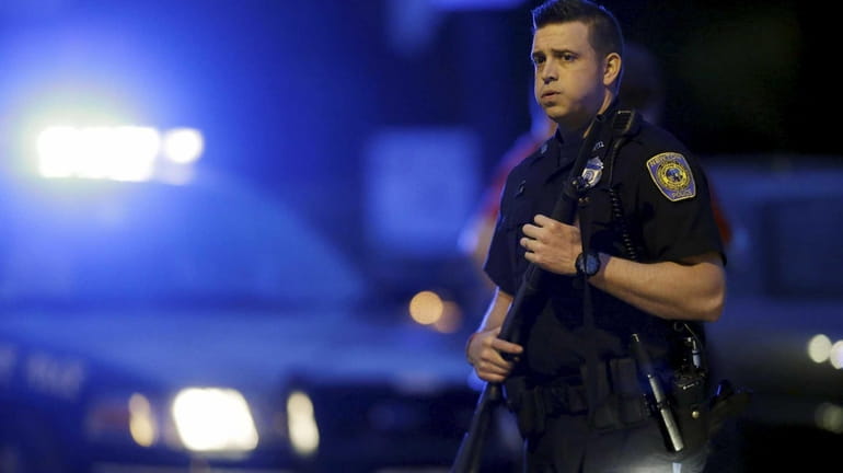 A police officer stands guard at the scene as the...