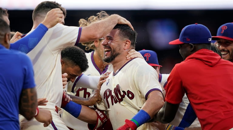 Philadelphia Phillies' Kyle Schwarber celebrates with teammates after hitting a...