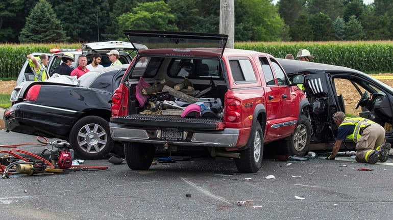Authorities investigate the scene of a fatal crash between a...