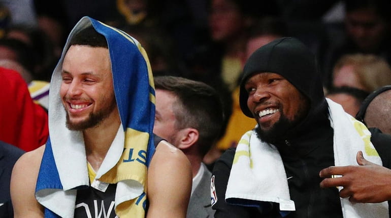 Stephen Curry jokes with Kevin Durant during a game against the...