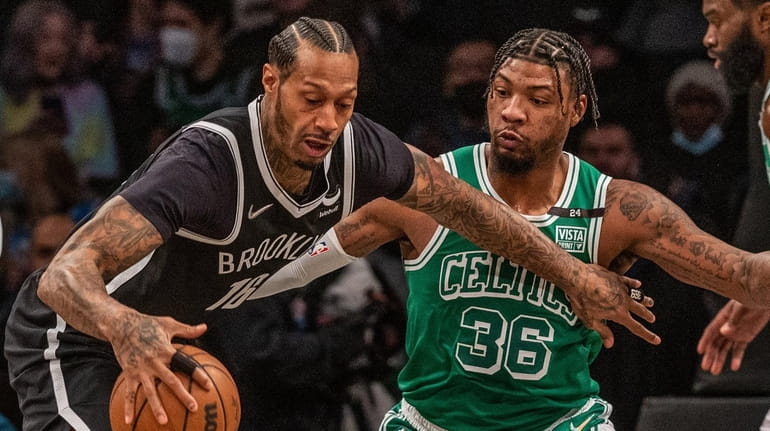 The Nets' James Johnson gets defensive pressure from Marcus Smart...