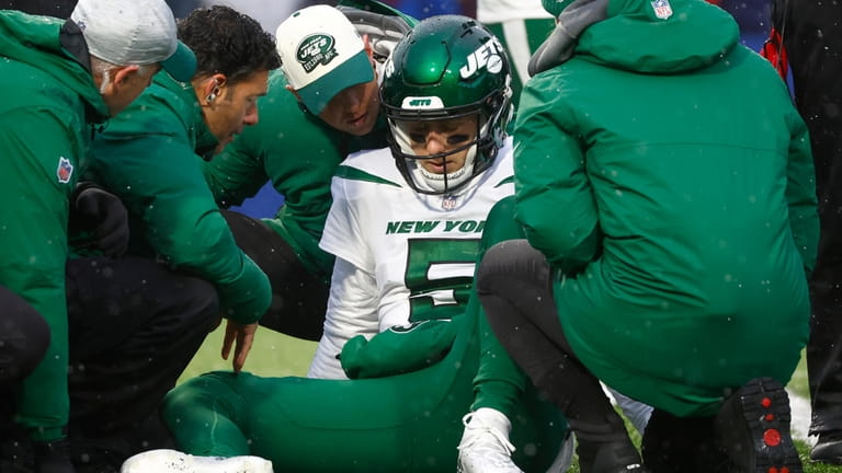 Jets quarterback Mike White receives assistance following a play in...
