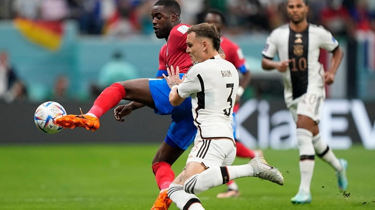Costa Rica's Joel Campbell, left, and Germany's David Raum challenge...