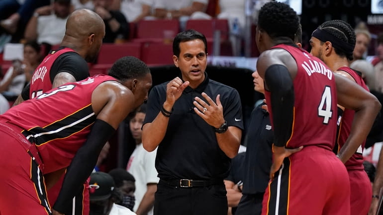 Miami Heat head coach Erik Spoelstra, center, talks with players...