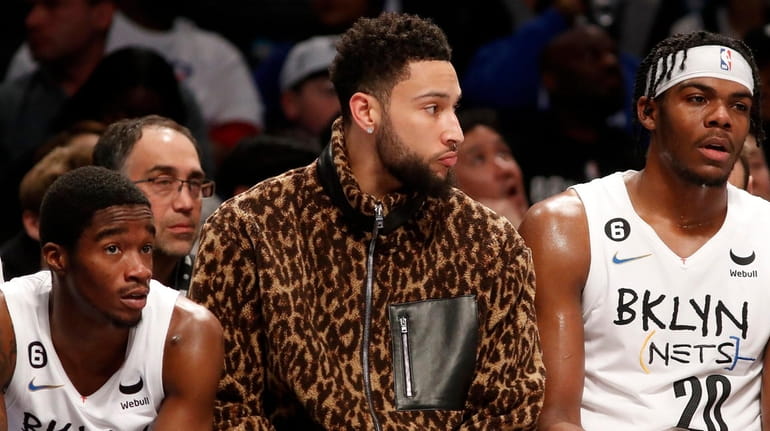 Ben Simmons of the Nets looks on from the bench...