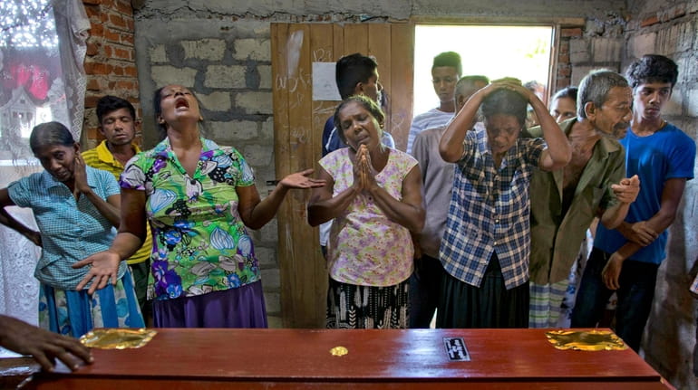 Relatives weep near the coffin with the remains of 12-year...