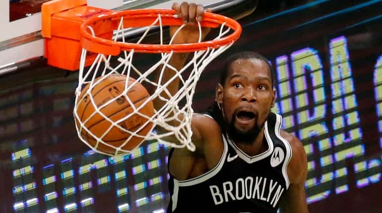 Nets forward Kevin Durant dunks during the second half of...