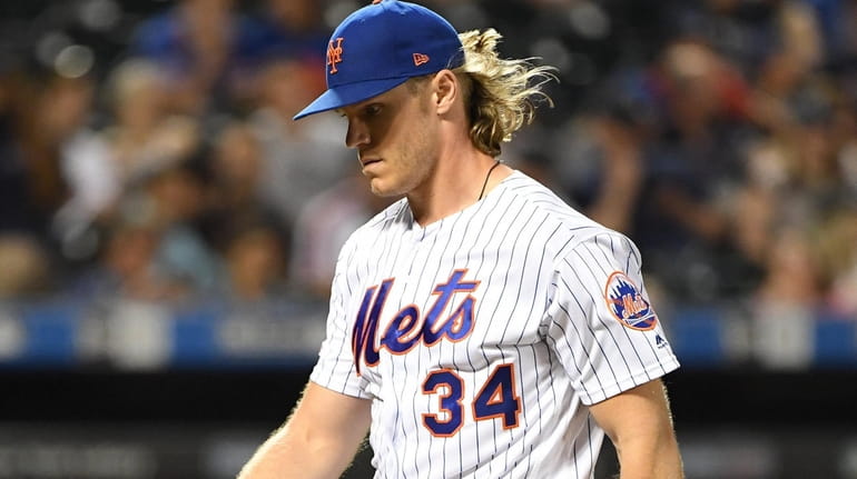New York Mets starting pitcher Noah Syndergaard walks to the...