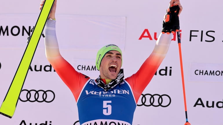 Switzerland's Daniel Yule celebrates on the podium after winning an...