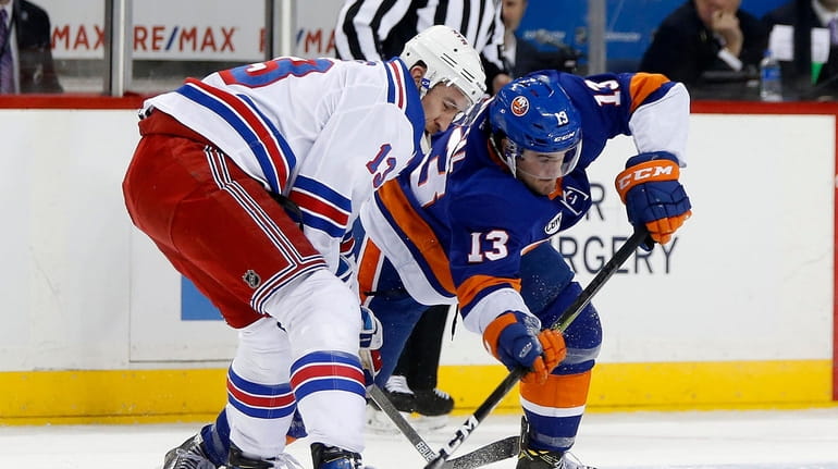 Mathew Barzal #13 of the New York Islanders tries to...