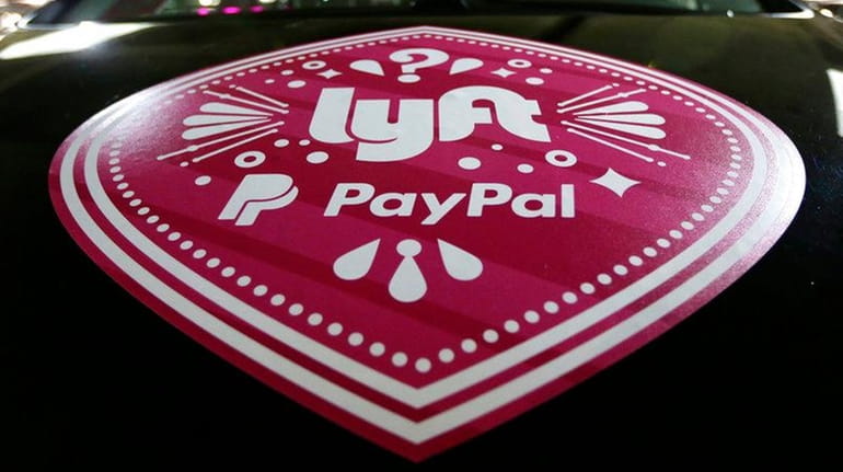 In this March 31, 2016, a Lyft ride-hailing service logo...