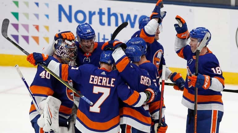 The Islanders celebrate after a shootout victory against the Boston...