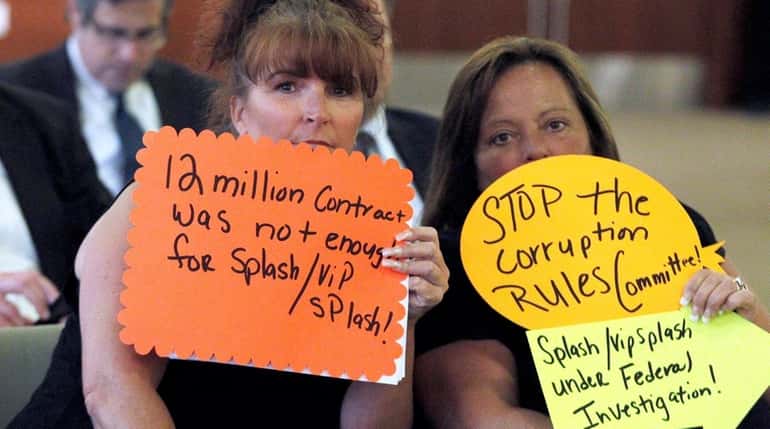 Patti Ambrosia, left, and Domenica Calafano hold signs objecting to...