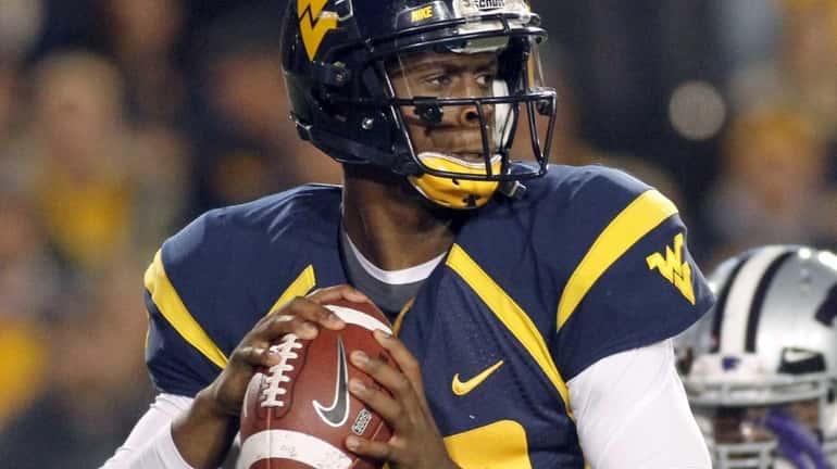 Geno Smith of the West Virginia Mountaineers drops back to...