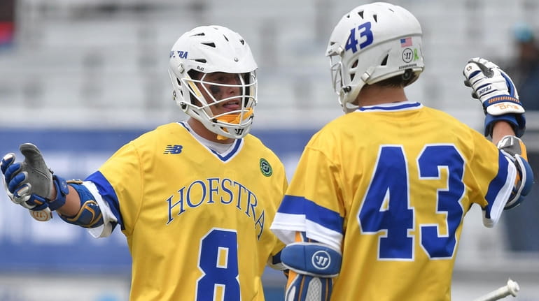 Jimmy Yanes #8 of Hofstra University, left, gets congratulated by...