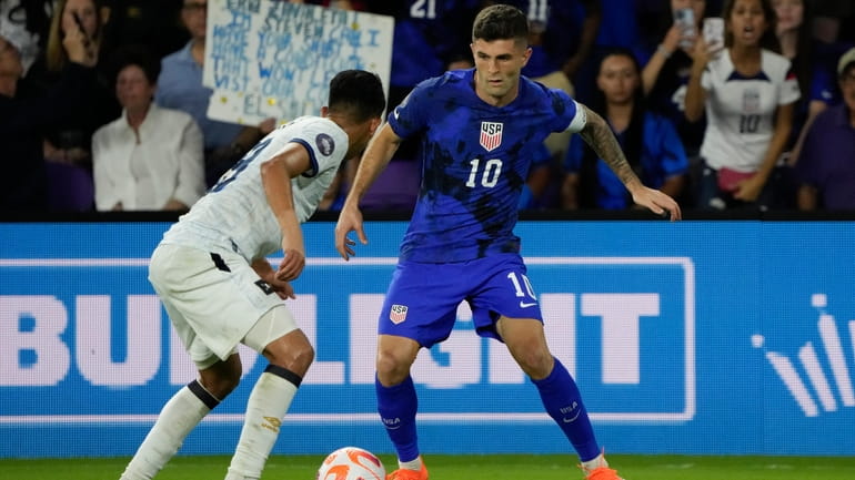 United States forward Christian Pulisic (10) looks for a way...