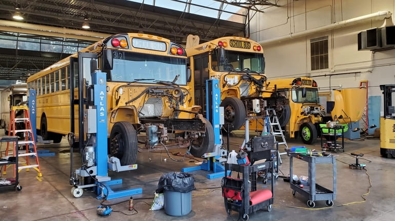 School buses being converted by Unique Electric Solutions Inc., from...