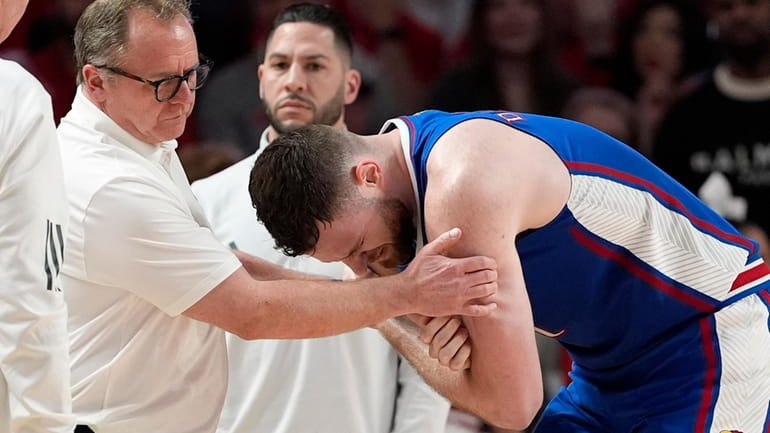 Kansas's Hunter Dickinson, right, is helped after being injured during...