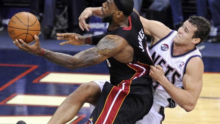 Miami Heat forward LeBron James, left, is fouled by New...