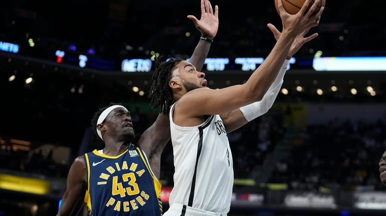 The Nets' Trendon Watford, right, shoots against the Pacers' Pascal...