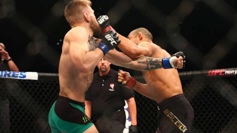 Conor McGregor, left, follows through on the knockout shot against...