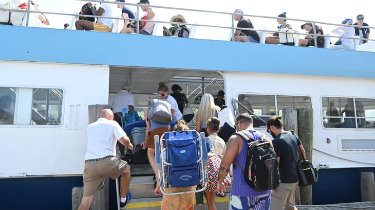 Passengers board the ferry in Sayville for the trip across...