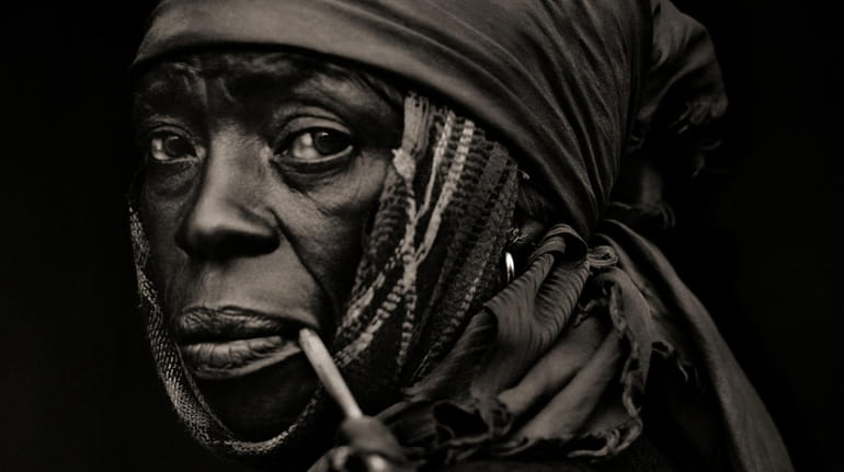 Dana Gluckstein's "Woman With Pipe, Traditional Medicinal Plant Healer, Haiti"...