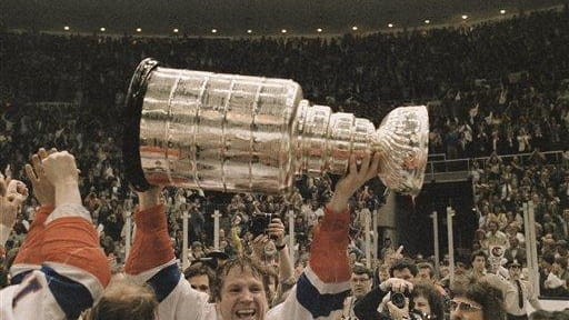 Islanders captain Denis Potvin holds the Stanley Cup after his...