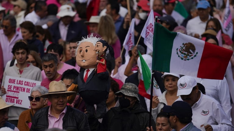 Demonstrators carry carry an effigy portraying Mexican President Andres Manuel...