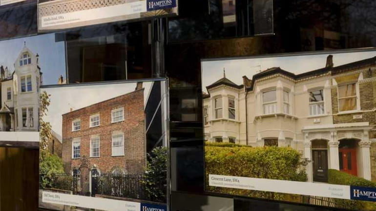 Photographs of properties are on view in the window of...