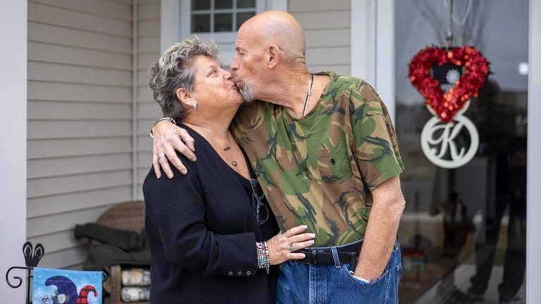 Laurie and Howard Kaminsky share a kiss outside their home...