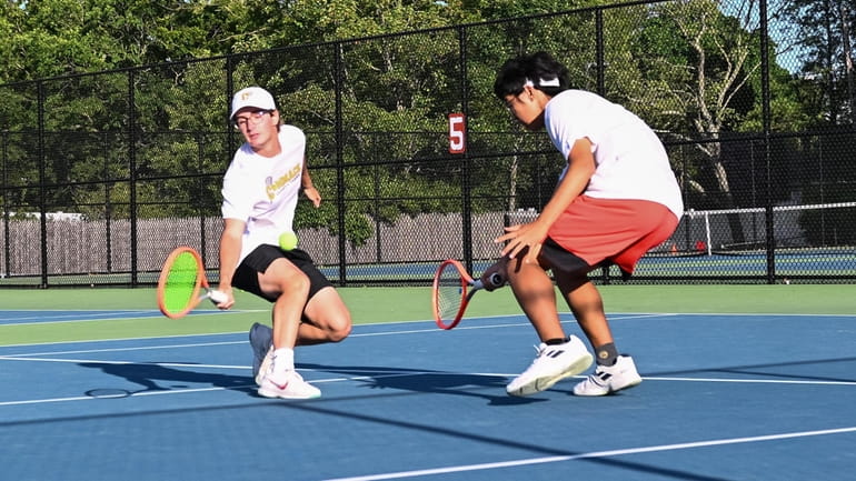 Commack doubles team Joe Romito (left) and James Yu synchronize...