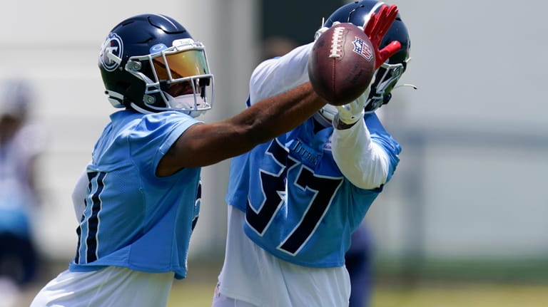 Tennessee Titans safety Kevin Byard, left, knocks the ball out...