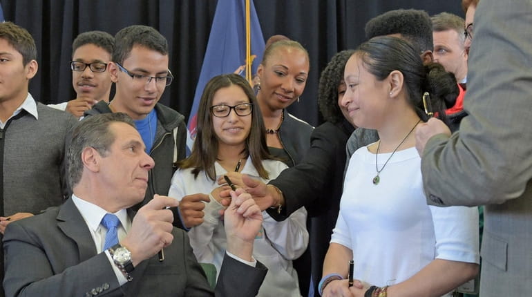 Gov. Andrew Cuomo hands out pens to Brentwood High School...