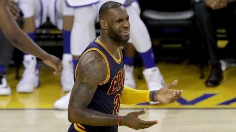 LeBron James of the Cleveland Cavaliers reacts in the second...
