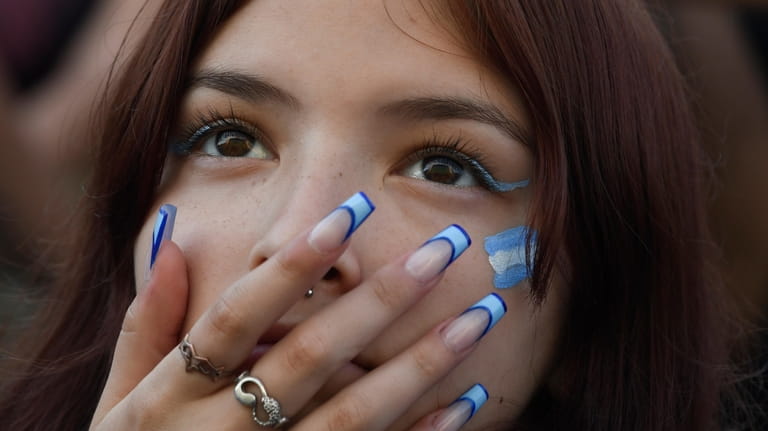 An Argentine soccer fan watches her team's match against Mexico...