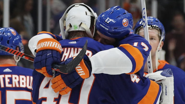 Islanders goalie Robin Lehner and Matt Martin hug following a...